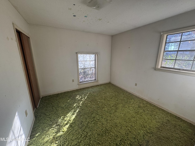 carpeted spare room with a textured ceiling