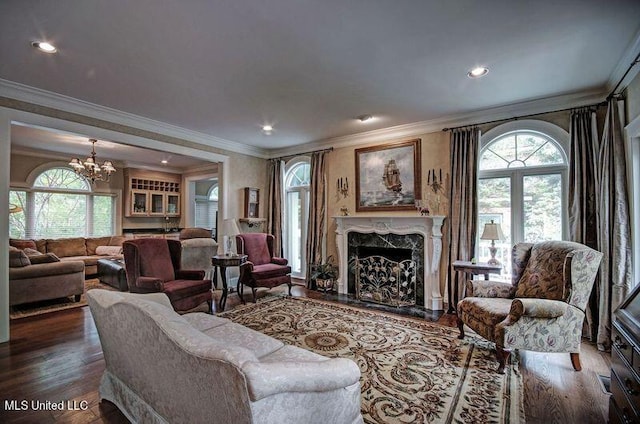 living room with ornamental molding, a chandelier, hardwood / wood-style floors, and a wealth of natural light