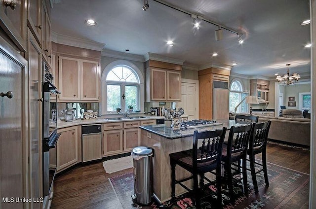 kitchen with sink, a kitchen island, dark hardwood / wood-style flooring, a notable chandelier, and ornamental molding