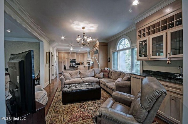 living room with sink, hardwood / wood-style floors, a notable chandelier, and ornamental molding