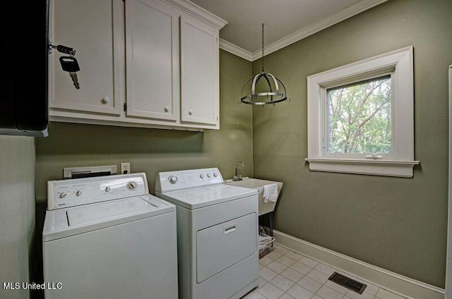 laundry area featuring cabinets, ornamental molding, washing machine and clothes dryer, and light tile patterned floors