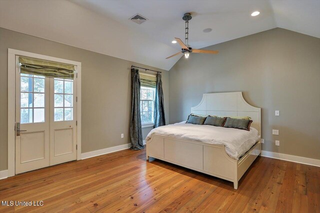 bedroom with ceiling fan, vaulted ceiling, and light wood-type flooring