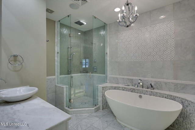 bathroom featuring tile walls, sink, plus walk in shower, and a chandelier