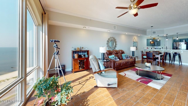 living room featuring ceiling fan, hardwood / wood-style flooring, and ornamental molding