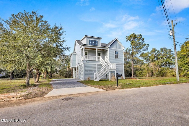 view of front of home featuring a carport, covered porch, and a front lawn