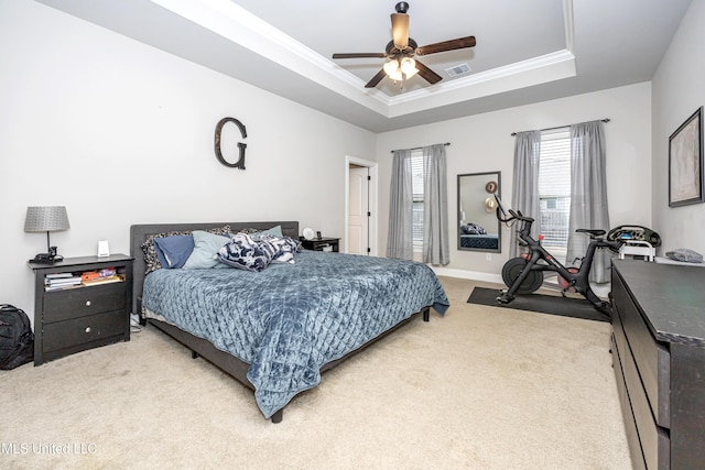 carpeted bedroom featuring a raised ceiling, ornamental molding, and ceiling fan