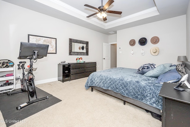 bedroom featuring ornamental molding, carpet flooring, ceiling fan, and a tray ceiling