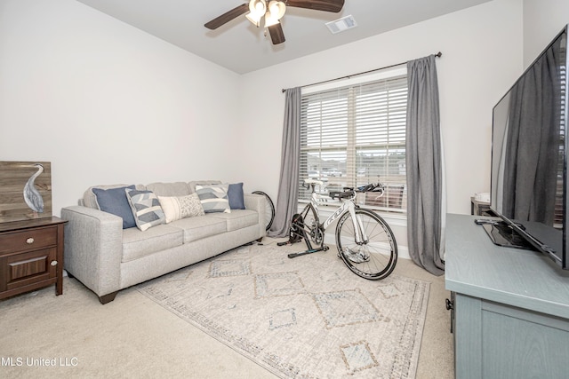 carpeted living room with ceiling fan