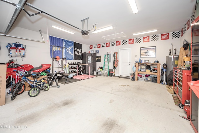 garage featuring a garage door opener, a workshop area, and water heater