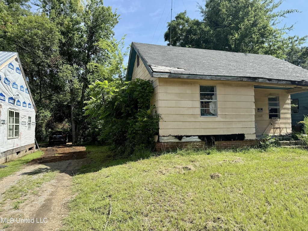 328 Idlewild St, Jackson, MS 39203 - view of side of property with a lawn and a shingled roof