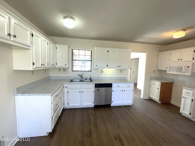 kitchen with a sink, dark wood finished floors, white cabinetry, white microwave, and dishwasher