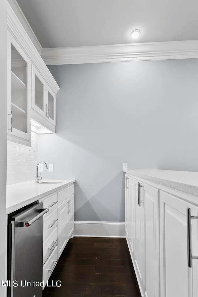 interior space with dishwasher, sink, white cabinetry, dark wood-type flooring, and ornamental molding