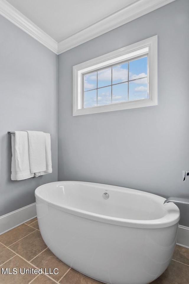 bathroom featuring a bathing tub, ornamental molding, and tile patterned flooring