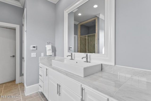 bathroom featuring a shower with shower door, vanity, tile patterned flooring, and crown molding