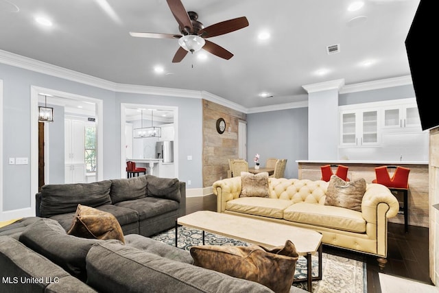 living room with light wood-type flooring, ornamental molding, and ceiling fan with notable chandelier