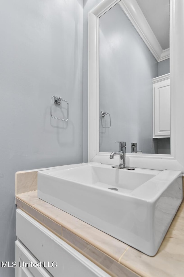 bathroom with vanity and ornamental molding