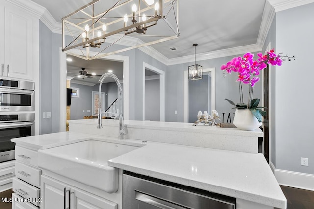 kitchen featuring appliances with stainless steel finishes, white cabinetry, dark hardwood / wood-style flooring, sink, and crown molding