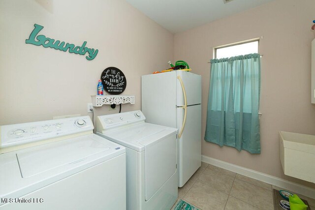 laundry area featuring light tile patterned floors and washer and dryer