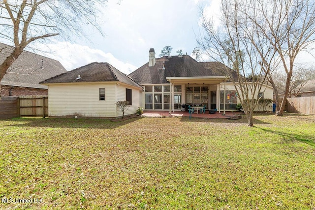 back of house featuring a yard, a sunroom, and a patio