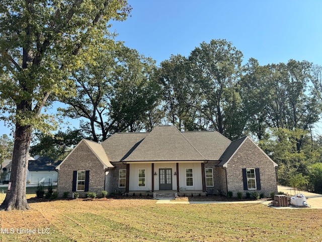 view of front of property with cooling unit and a front lawn