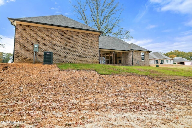 view of side of property with a lawn and central AC unit