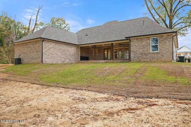 rear view of house featuring cooling unit and a yard