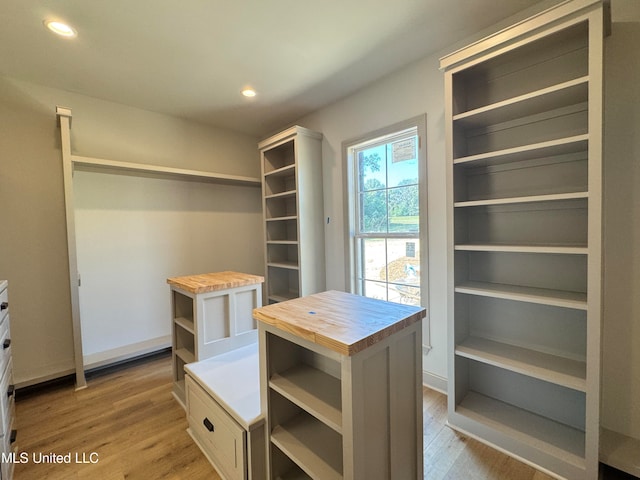 walk in closet with light hardwood / wood-style flooring