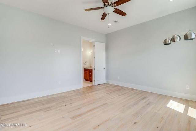 spare room with light wood-style flooring, baseboards, visible vents, and ceiling fan