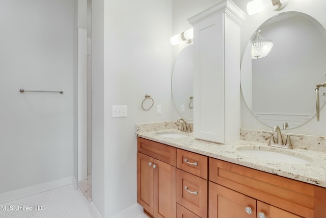 full bathroom featuring a sink, baseboards, and double vanity