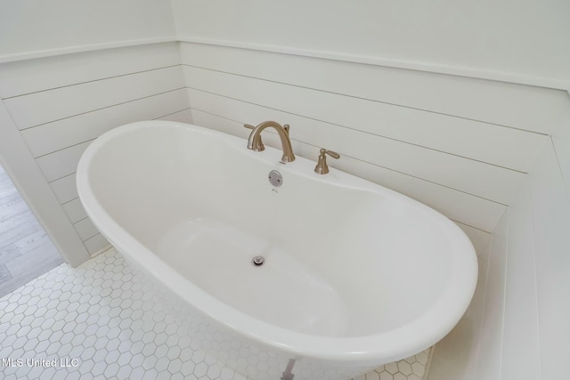 bathroom with tile patterned flooring and a soaking tub