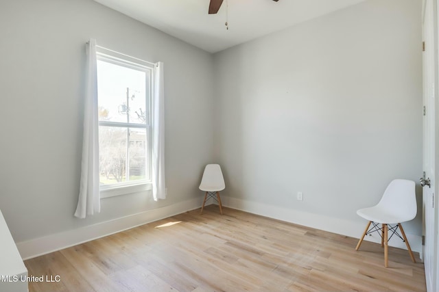 spare room featuring baseboards, ceiling fan, and wood finished floors