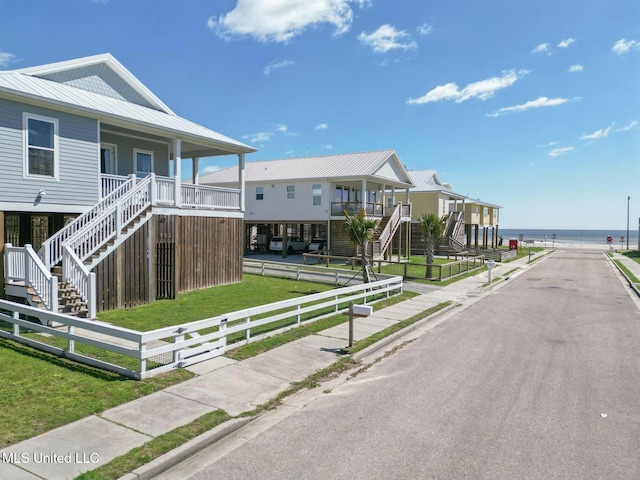 view of road featuring stairway, a water view, and sidewalks