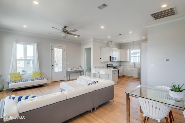 living area with plenty of natural light, visible vents, and light wood-type flooring