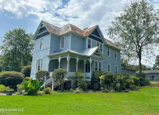 view of front of property with covered porch and a front lawn