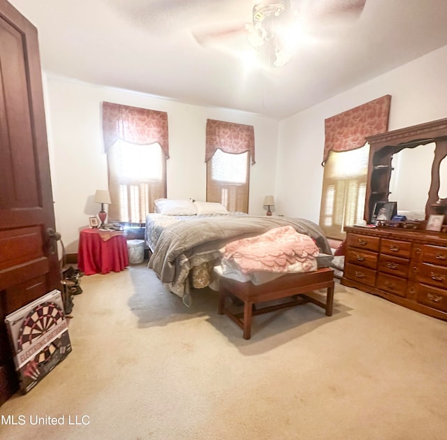 bedroom featuring ceiling fan, carpet, and multiple windows