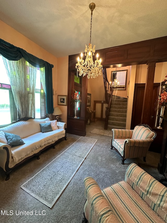 living room featuring a notable chandelier, a textured ceiling, and carpet flooring