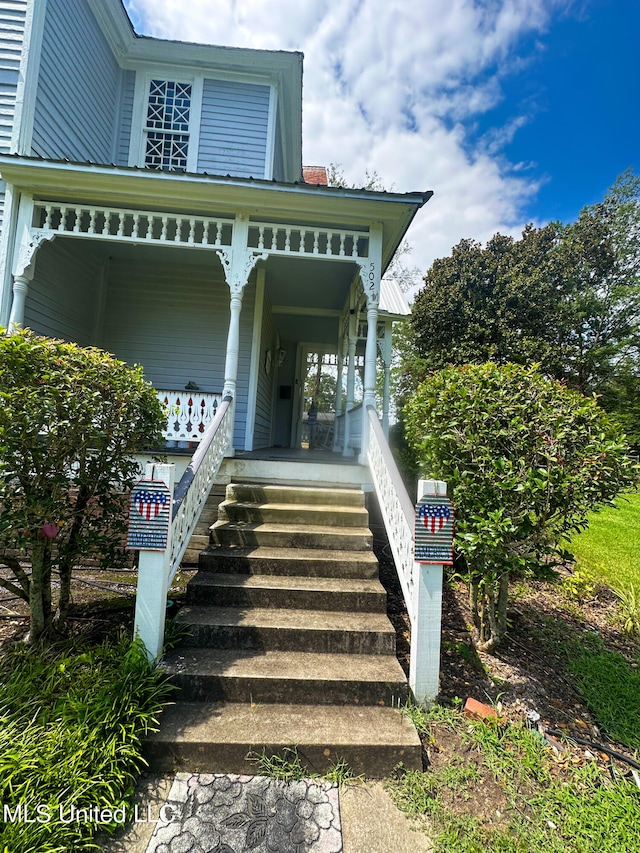 view of exterior entry featuring covered porch