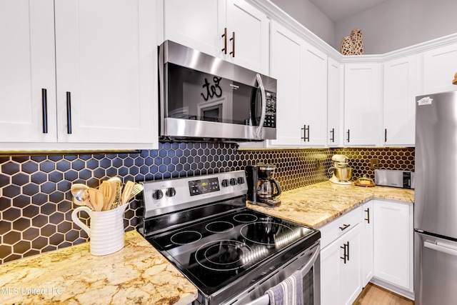 18109 Evergreen Dr, Gulfport, MS 39503 - kitchen featuring appliances with stainless steel finishes, white cabinetry, backsplash, and light stone countertops