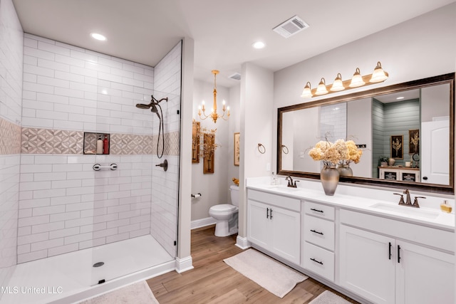18109 Evergreen Dr, Gulfport, MS 39503 - full bath with double vanity, a tile shower, wood finished floors, a chandelier, and recessed lighting
