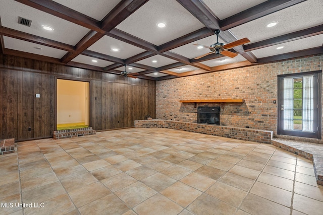 unfurnished living room featuring beamed ceiling, coffered ceiling, and ceiling fan