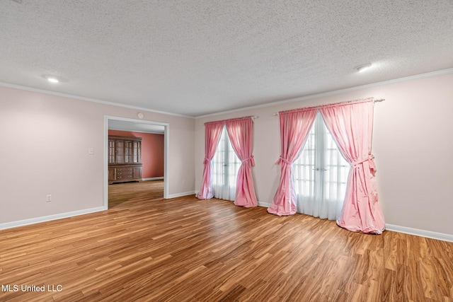 unfurnished room featuring wood finished floors, baseboards, and ornamental molding