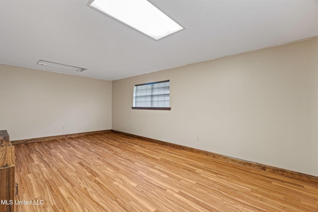 spare room featuring light wood-style flooring and baseboards