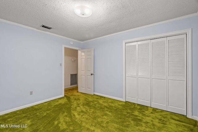 unfurnished bedroom featuring visible vents, baseboards, a closet, ornamental molding, and carpet flooring