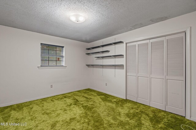 unfurnished bedroom with a closet, carpet, a textured ceiling, and baseboards