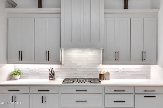 kitchen featuring decorative backsplash, white cabinets, and stainless steel gas cooktop