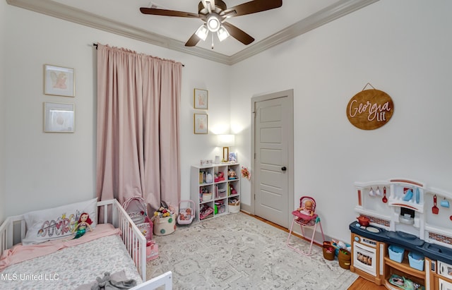 bedroom with ceiling fan, a nursery area, and ornamental molding