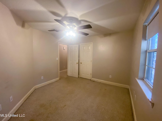 unfurnished bedroom featuring light carpet and ceiling fan