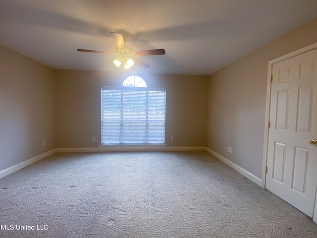 carpeted spare room featuring ceiling fan