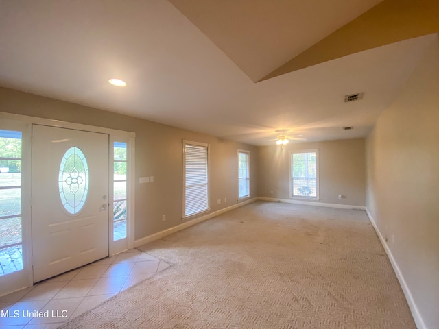 entryway with lofted ceiling, a healthy amount of sunlight, and light colored carpet