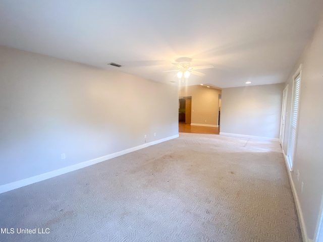 carpeted spare room with ceiling fan